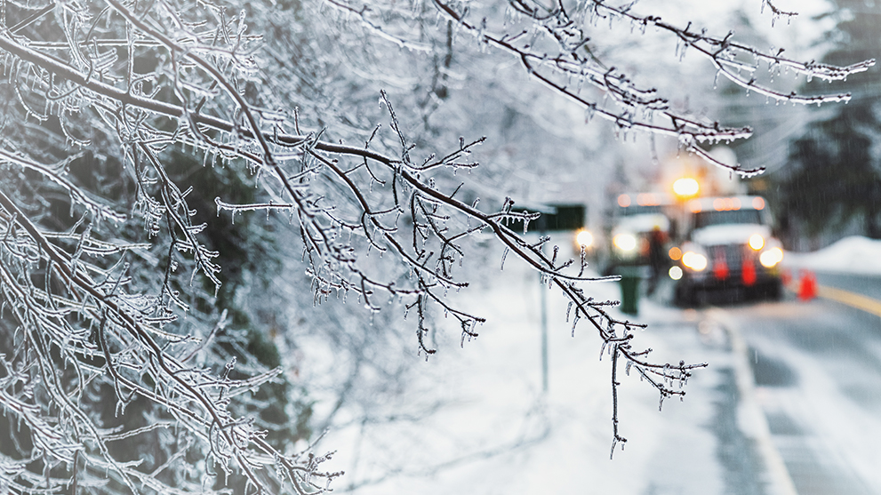 Natural gas service trucks driving down a snowy road